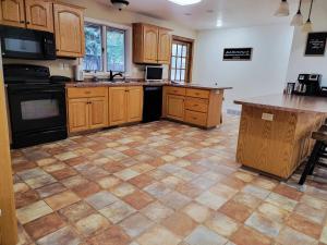 a kitchen with wooden cabinets and a tile floor at Dakota Lodge in Dickinson