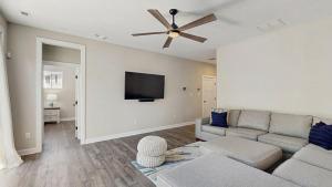 a living room with a couch and a flat screen tv at Bethany Woods - 31600 Charleys Run in Bethany Beach