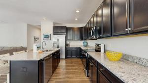 a kitchen with black cabinets and marble counter tops at Bethany Woods - 31600 Charleys Run in Bethany Beach