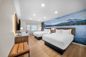 a hotel room with two beds and a television at Clarion Pointe Kent - Seattle South in Kent +48 photos