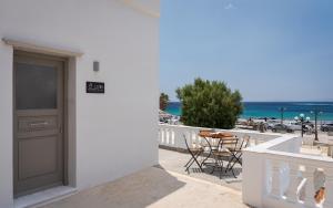 a balcony with a door and a table and chairs at Limen Port View Studio in Tinos
