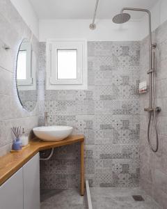 a bathroom with a sink and a shower at Limen Port View Studio in Tinos +8 photos