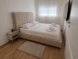 a bedroom with a bed with two towels on it at Mare Ann in Ljubuški