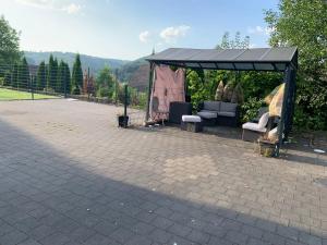 a gazebo with a couch and chairs under it at Haus Tun in Gummersbach