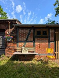 a brick building with a porch and two chairs at Alte Dorfschule Sacro in Sacro