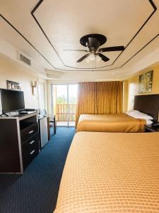 a hotel room with two beds and a ceiling fan at ORO North Beach Inn in Corpus Christi +7 photos