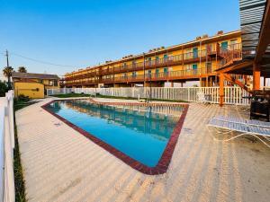 a large swimming pool in front of a building at ORO North Beach Inn in Corpus Christi