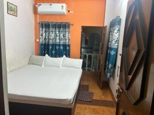 a small room with a bed and a window at Priyadarshi Hotel in New Digha