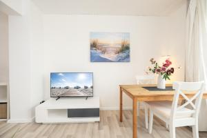 a living room with a table and a television at Fördeperle Laboe in Laboe