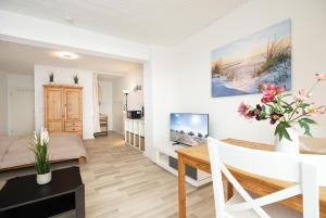 a living room with a wooden table and a dining room at Fördeperle Laboe in Laboe +10 photos