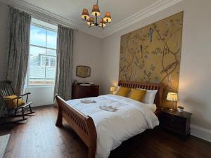 a bedroom with a large bed with a painting on the wall at Kirkland in Berwick-Upon-Tweed