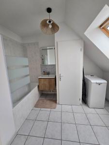 a bathroom with a tub and a sink and a door at Charmante maison Marnaise in Vauclerc +13 photos