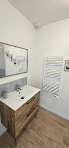 a bathroom with a sink and a mirror at La mie du Hom in Thury-Harcourt