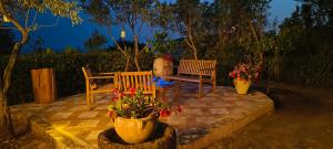 two chairs and a bench on a patio at night at Splendida villa in riva al mare in Orosei