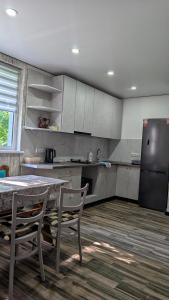 a kitchen with a table and a black refrigerator at Хата над гуком in Kosiv
