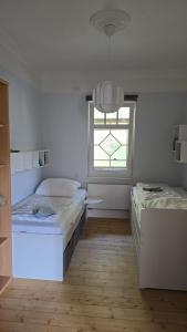 a white room with two beds and a window at Villa Beckurts in Wernigerode