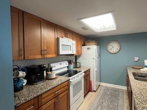 a kitchen with white appliances and a clock on the wall at Egrets Pointe, Unit 492 in Edisto Island