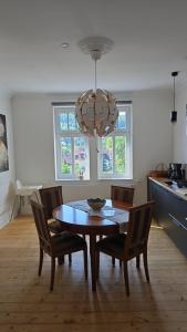 a dining room table with chairs and a chandelier at Villa Beckurts in Wernigerode