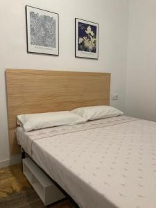 a bed in a bedroom with two pictures on the wall at Caliu Tremp in Tremp