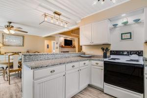 a kitchen with white cabinets and a stove top oven at Heh Edisto in Edisto Beach +15 photos