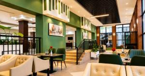 a restaurant with green walls and tables and chairs at Ras Hotel - Harar in Hārer
