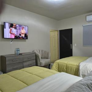ein Hotelzimmer mit zwei Betten und einem Flachbildfernseher in der Unterkunft Mukí Galá in Creel + 33 Fotos