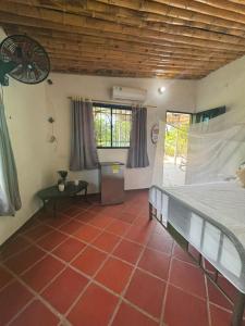 a bedroom with a bed and a red tile floor at Casa chill out in Minca