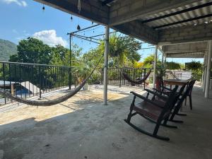 a porch with a hammock and a table and chairs at Casa chill out in Minca