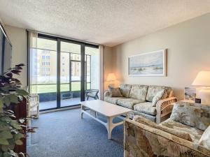 a living room with a couch and a table at Beachfront with a pool at Ocean Trillium Condo ~ 101 in New Smyrna Beach +34 photos