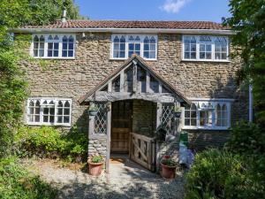 a brick house with a wooden door and a gate at Ivy Cottage in Bath