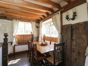 a dining room with a wooden table and chairs at Ivy Cottage in Bath