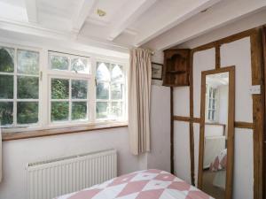 a bedroom with two windows and a bed in it at Ivy Cottage in Bath