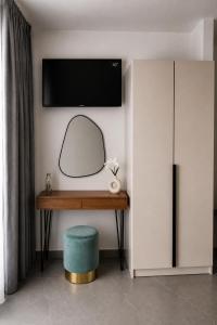 a room with a desk with a mirror and a tv at Haraki Emerald in Haraki