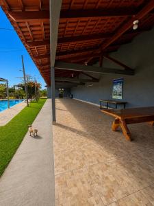 a dog laying on the ground next to a bench at Flats Araras do Vale in Colinas Do Sul