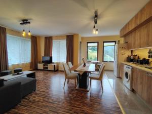 a kitchen and living room with a table and chairs at Апартамент за гости Александър in Chepelare +13 photos