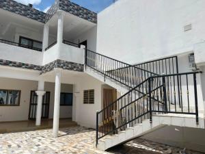 a staircase in a white building with a stair case at RESIDENCE Chez PETER in Alakopé