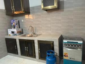 a kitchen with a sink and a stove at RESIDENCE Chez PETER in Alakopé