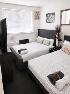 a room with three beds and a tv at Roclems Homes in Grays Thurrock +1 photo