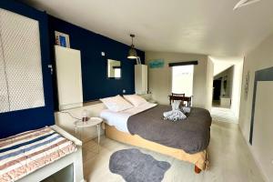 a bedroom with a bed and a blue wall at Maison de charme 8p Jardin Baie de Somme in Abbeville