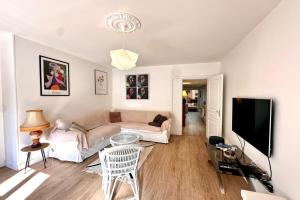 a living room with a couch and a tv at Maison de charme 8p Jardin Baie de Somme in Abbeville +36 photos