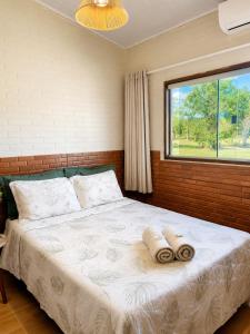 a bedroom with a bed with two towels on it at Chalés Araras do Vale in Colinas Do Sul +57 photos