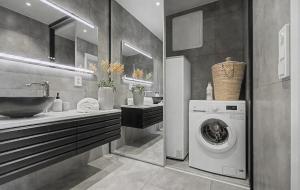 a bathroom with a washing machine and a sink at Central apartment in quiet area in Ålesund