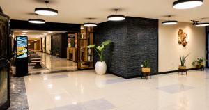 a lobby with a brick wall and a white vase with plants at Ras Hotel - Harar in Hārer