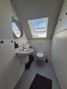 a bathroom with a sink and a toilet with a window at Rebenmeer Wohnung in Roschbach in Roschbach +34 photos