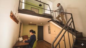 a man and a woman sitting at a desk with a laptop at La Joya Hostel in Valparaíso +71 photos