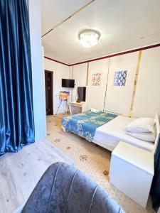 a bedroom with two beds and a tv at Heyvah - Guest House in Tashkent in Tashkent