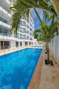 a large swimming pool with palm trees in front of a building at Sea View 603B in San Andrés