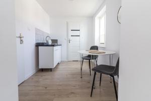 a kitchen with a table and chairs in a room at Ada Niechorze in Niechorze