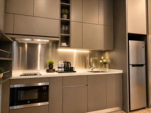 a kitchen with stainless steel cabinets and a sink at Ceylonz Suites KLCC By KL Tower in Kuala Lumpur