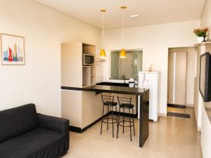 a kitchen and living room with a table and chairs at Vêneto Flat Residence (AP-13) in Primavera do Leste